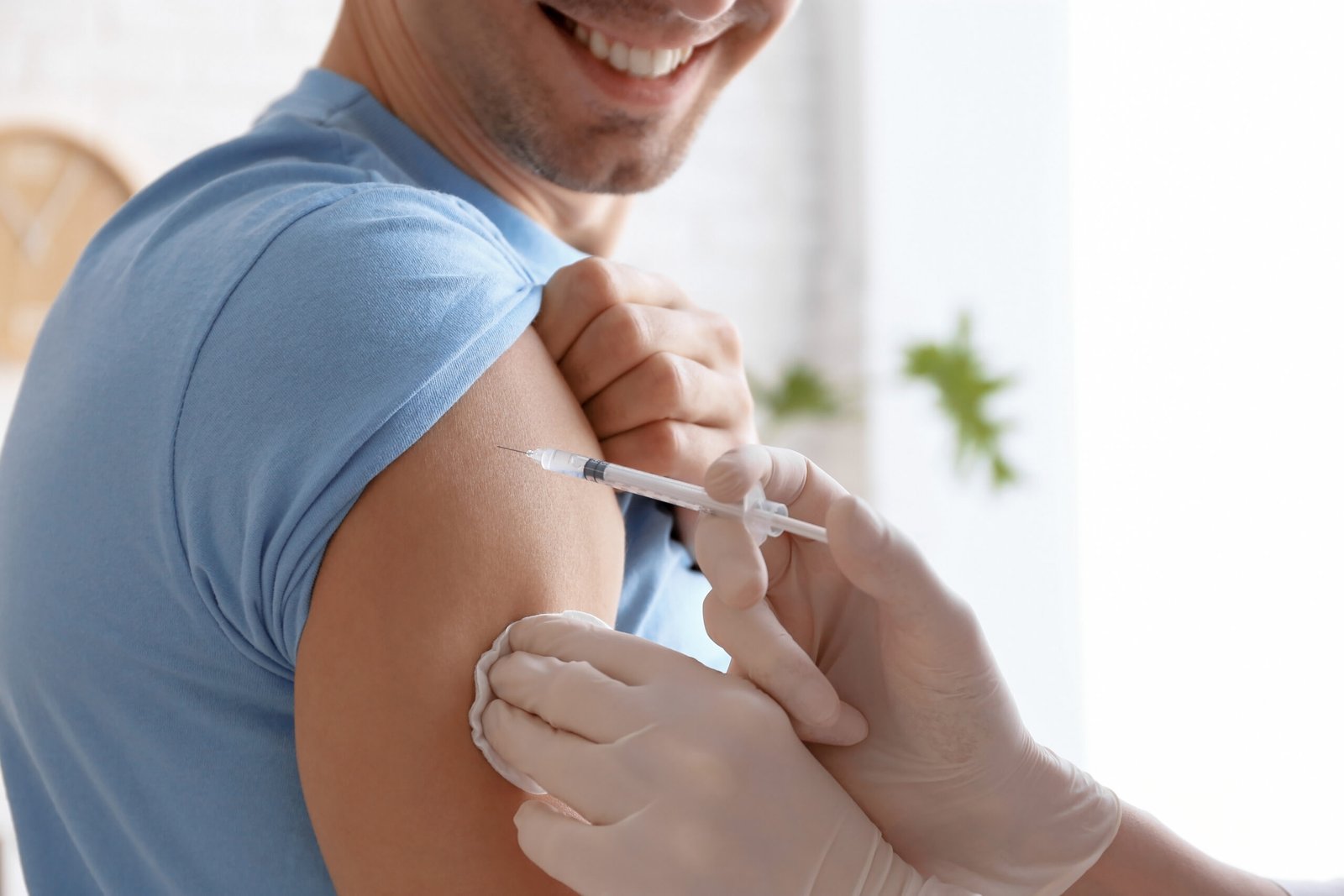 Hombre sonriendo siendo vacunado por una enfermera